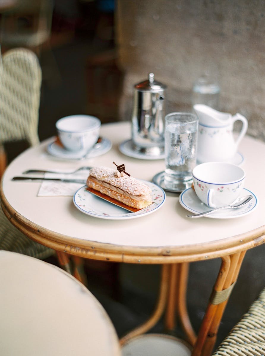Charming café table with a delicious pastry and fine china, creating a cozy dining atmosphere.