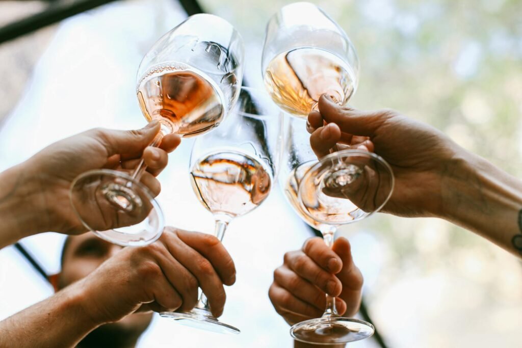 A group of friends toasting with wine glasses in a joyful outdoor celebration.
