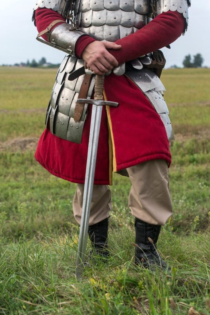 A person wearing a knight costume and holding a sword, viewed from the chest down.