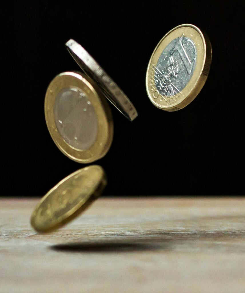 Four euro coins dropping onto a table