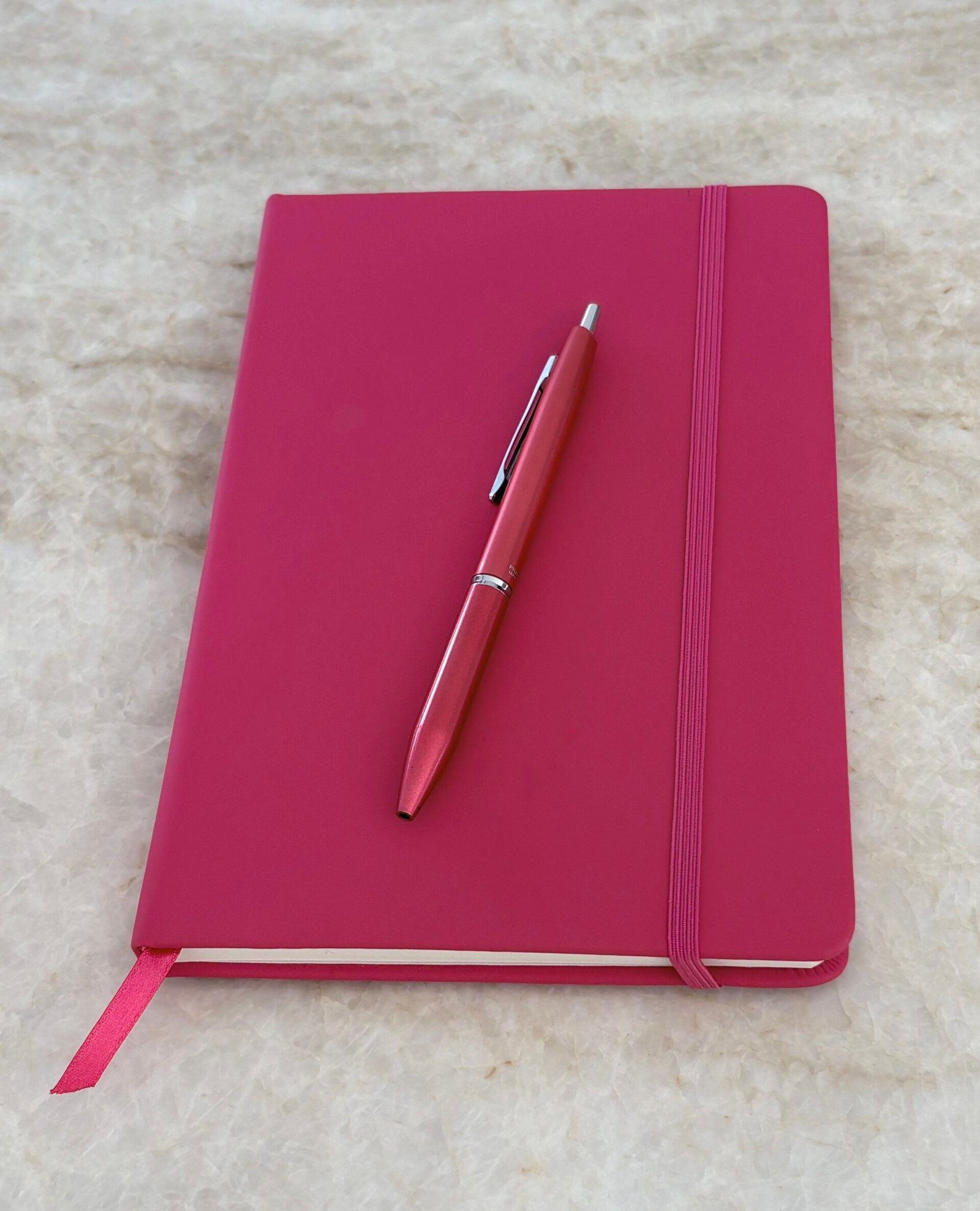 A pink journal and pen for French writing practice