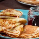 A plate of French crepes with honey and jam