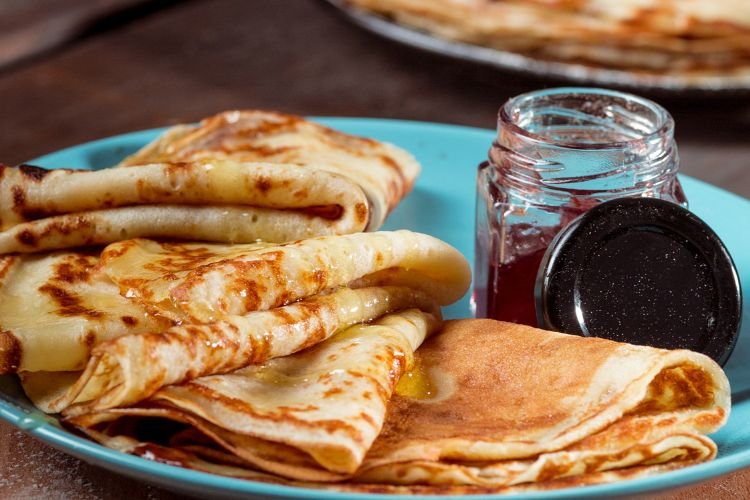 A plate of French crepes with honey and jam