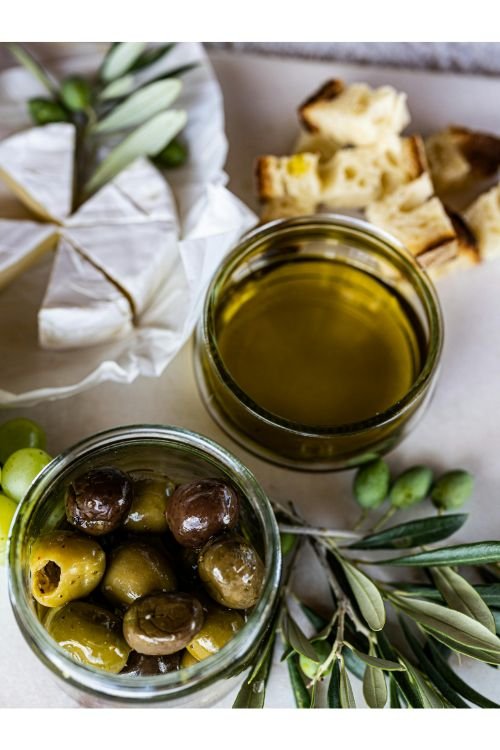 Olive oil and olives with bread and cheese